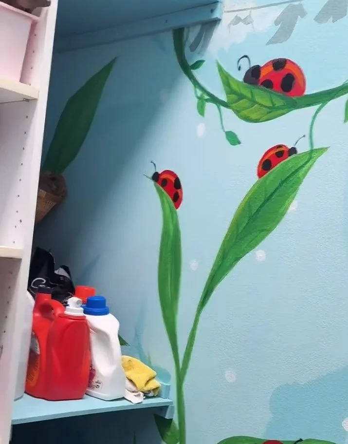Hand-painted ladybug and vine mural in a laundry room in Indio, CA by SoCal Murals