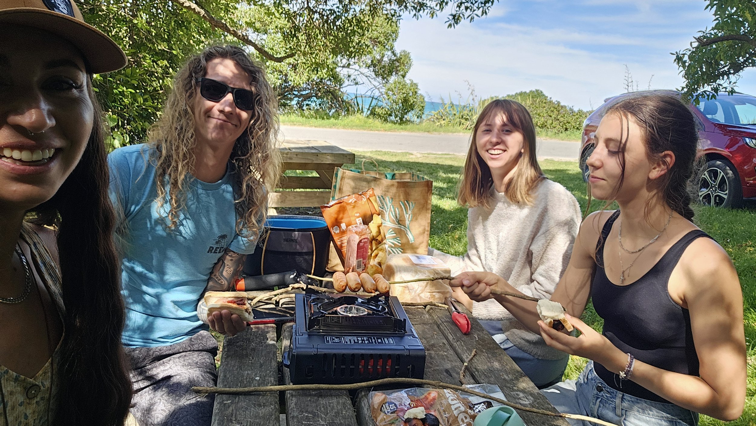 Family picnic beneath the trees overlooking Gore Bay beach