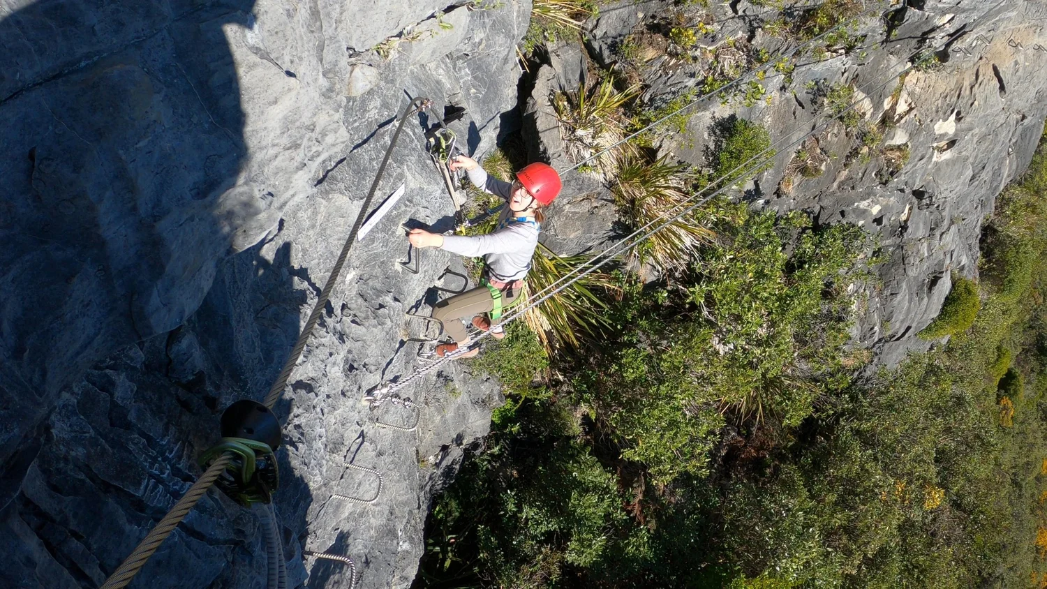Angelina climbing down an exposed section toward the three-wire bridge