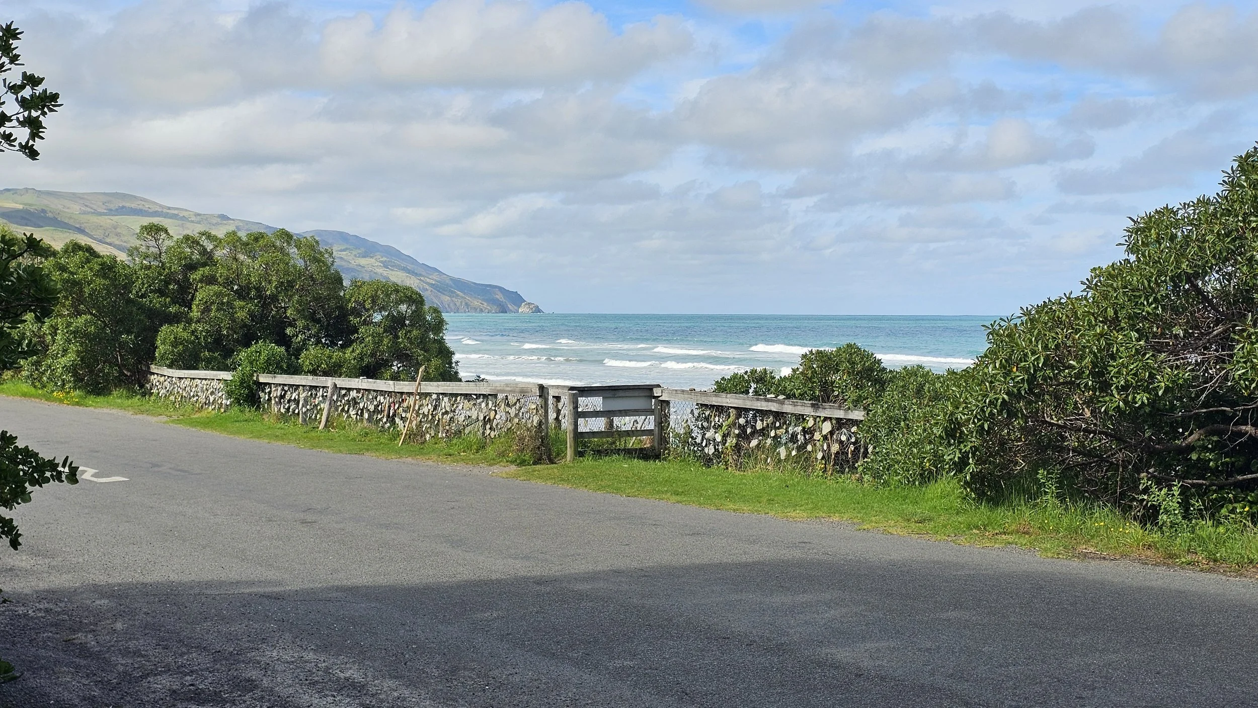 Beach access fence covered with shells and naturally holed stones