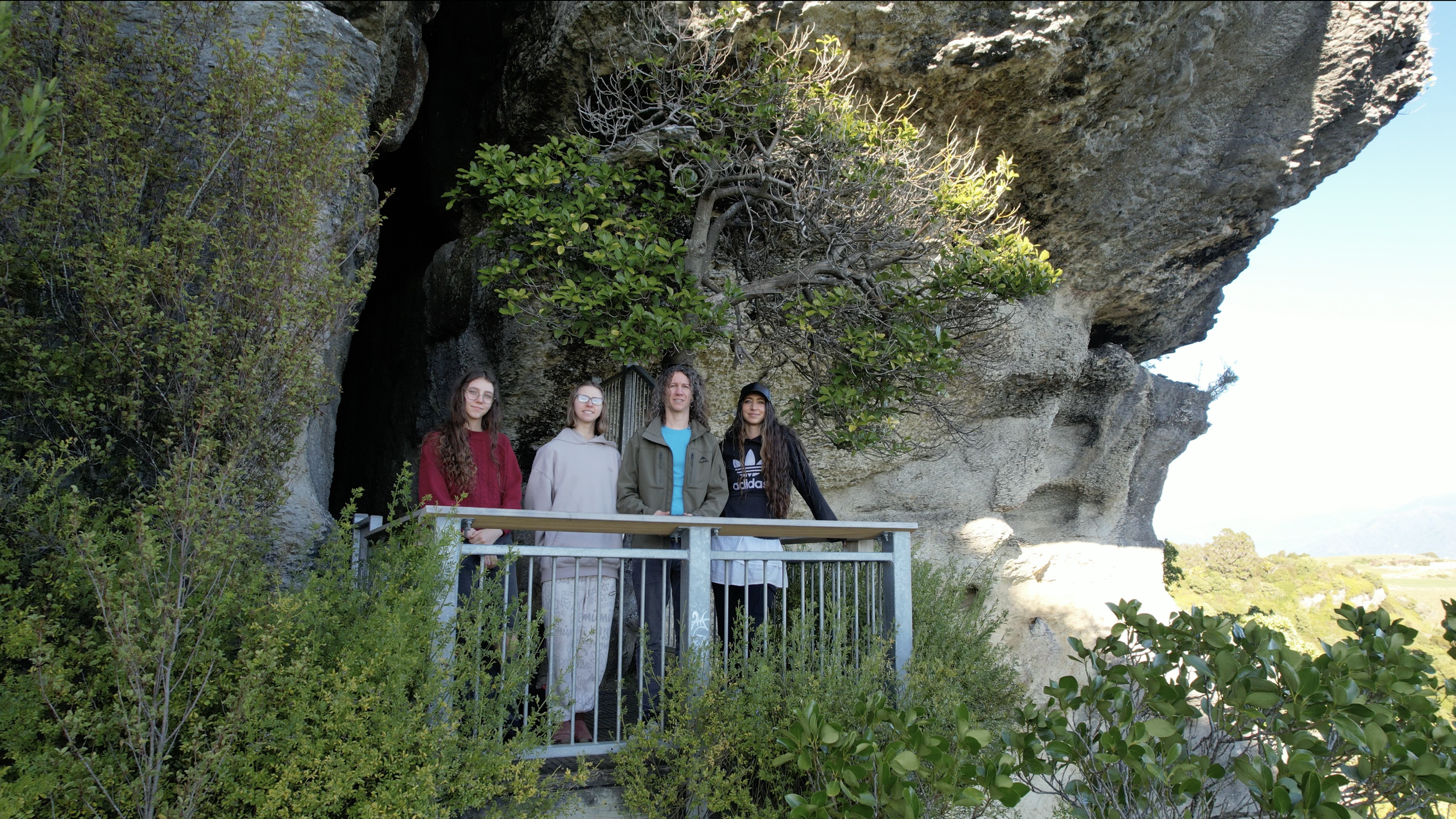 The Scenic Route family standing on the fenced lookout at The Grove Scenic Reserve