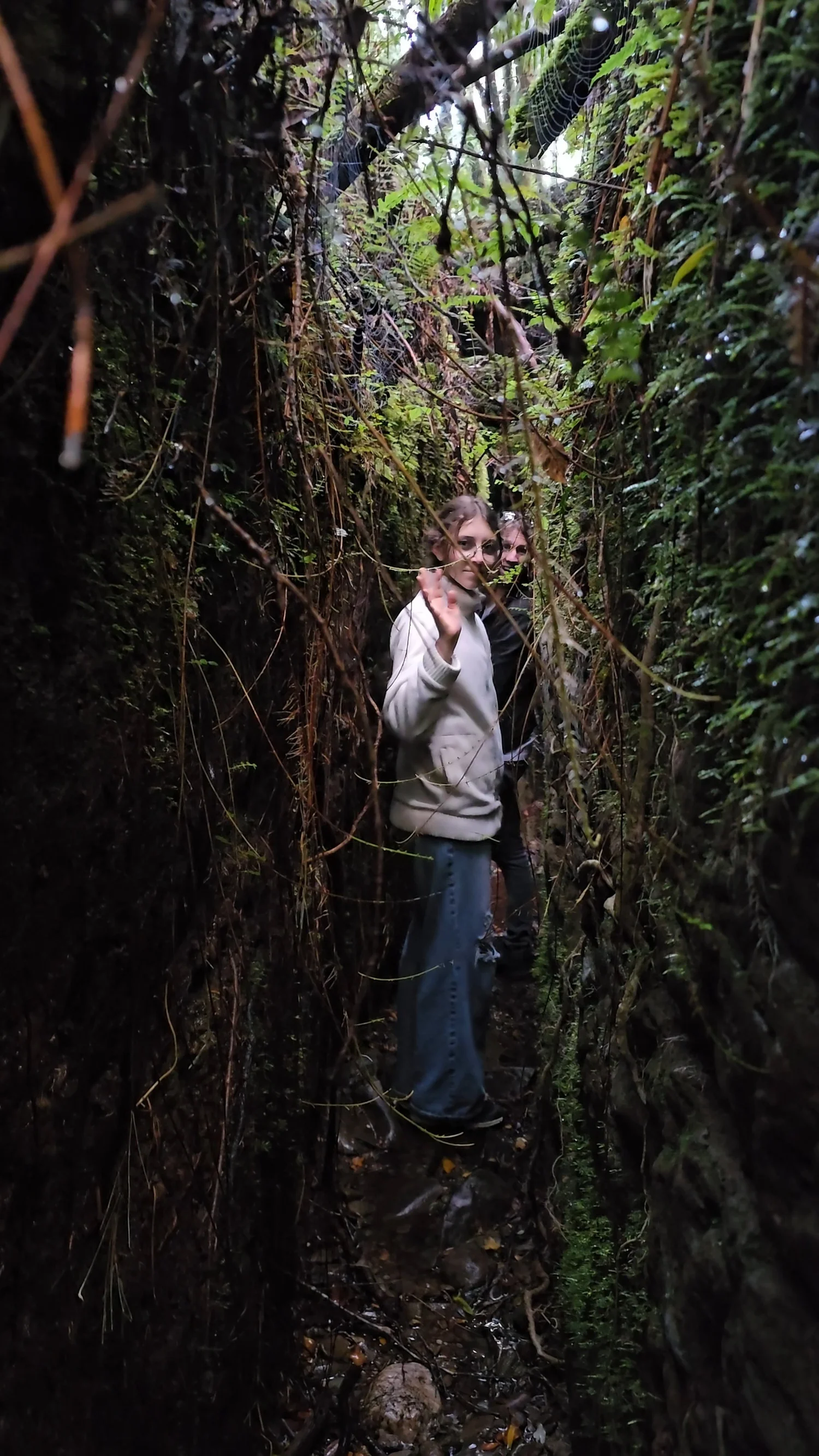 Family member standing sideways inside the narrow Blue Spur water race