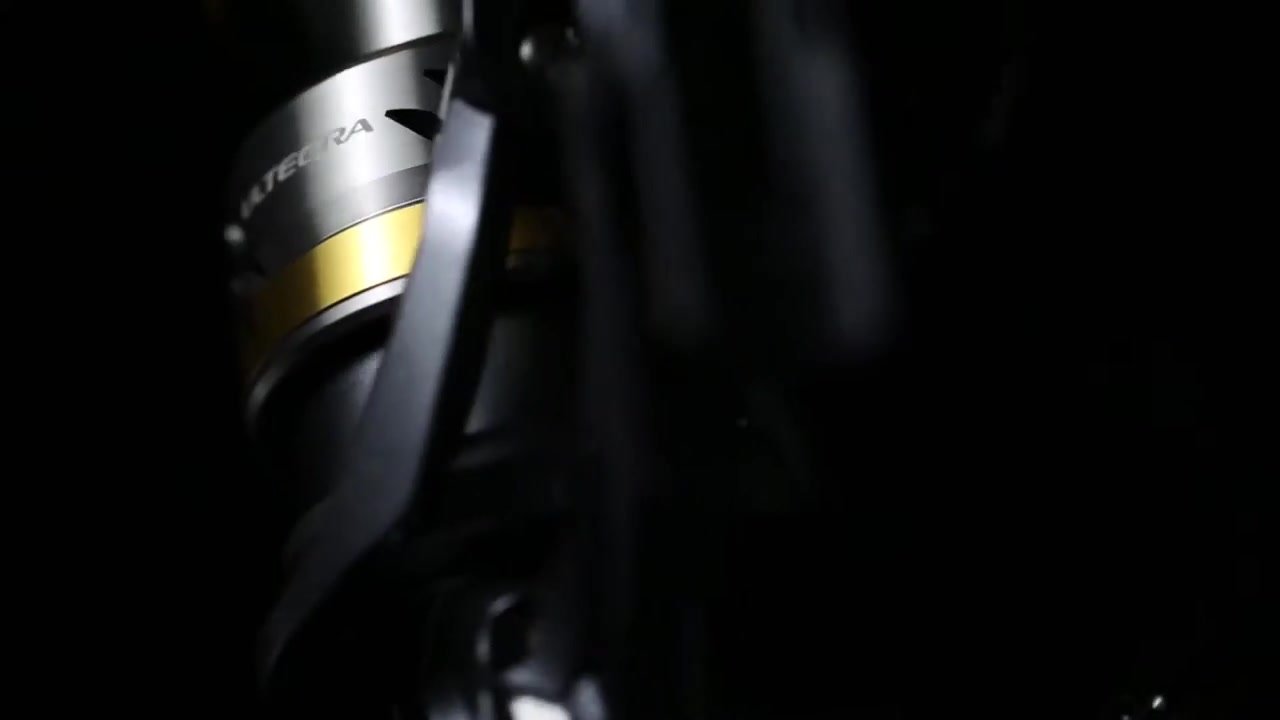 Ultegra reel with gold spool against black in my studio product film.