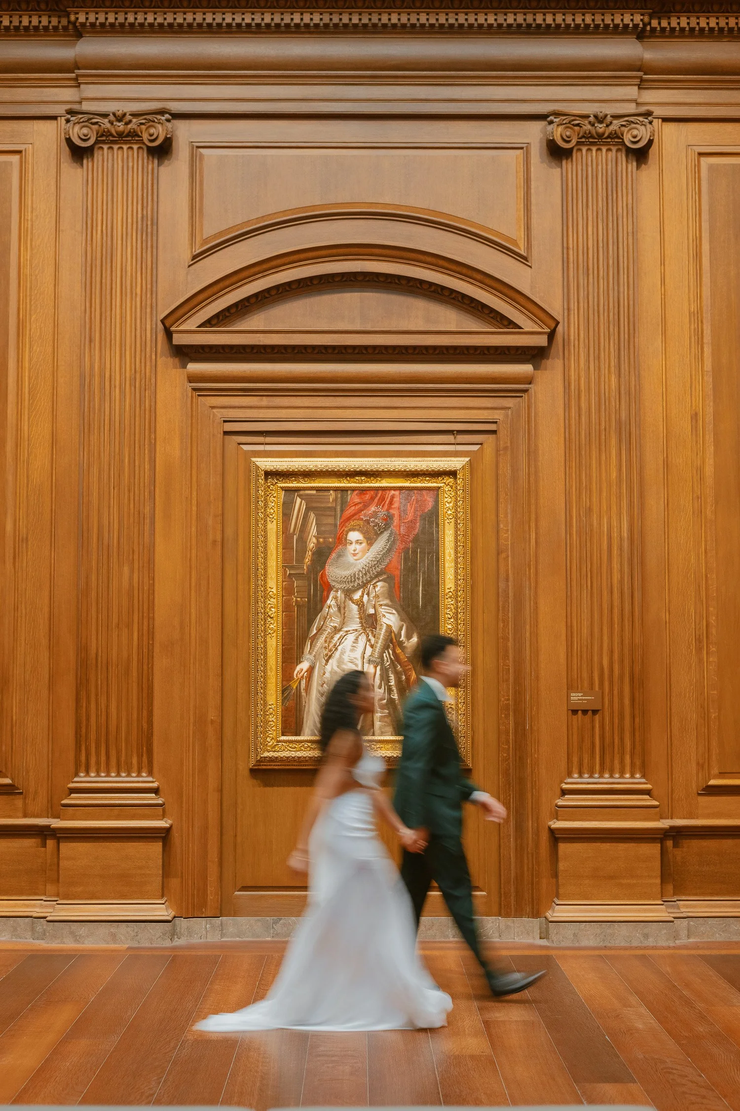 Couple walking past a painting with soft intentional motion blur.