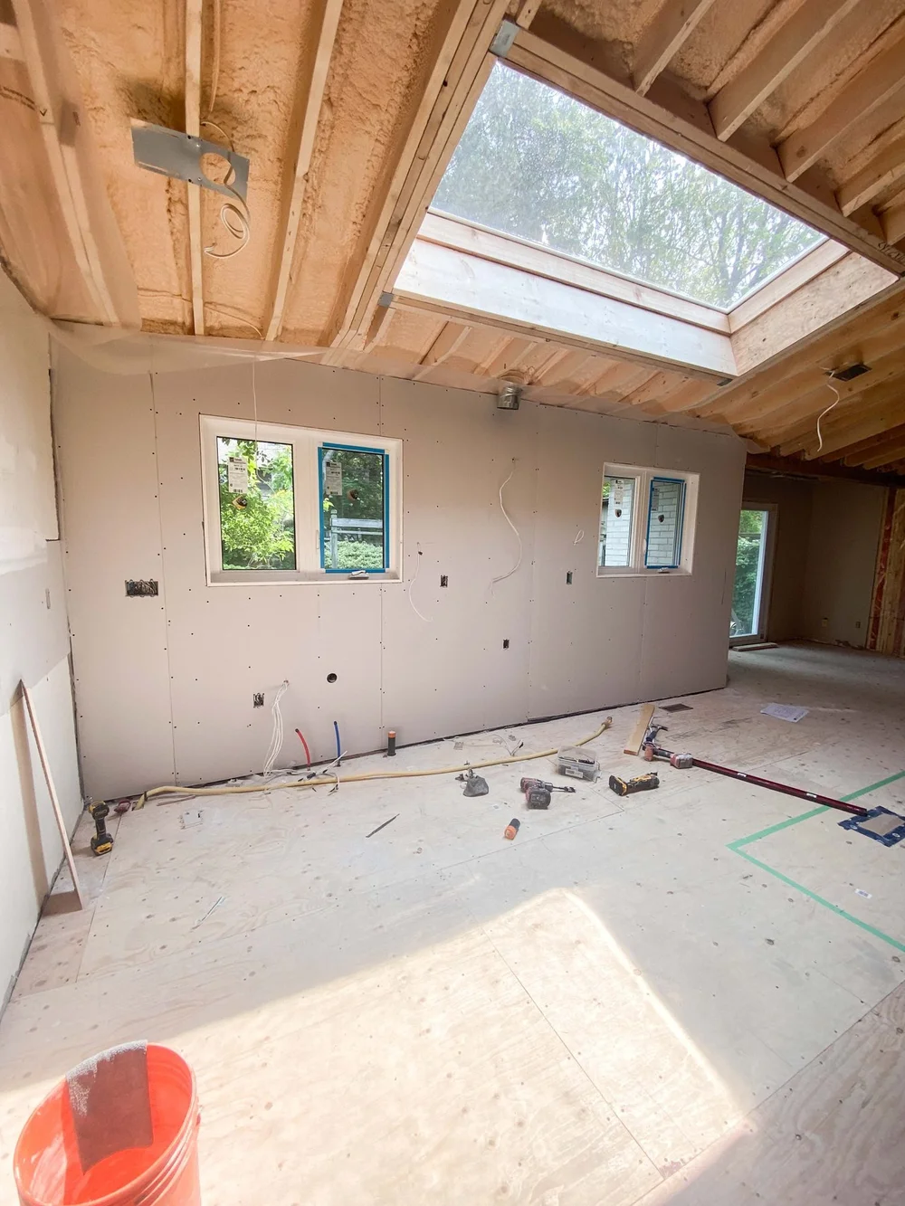 Installed wall drywall beneath an open ceiling and skylight