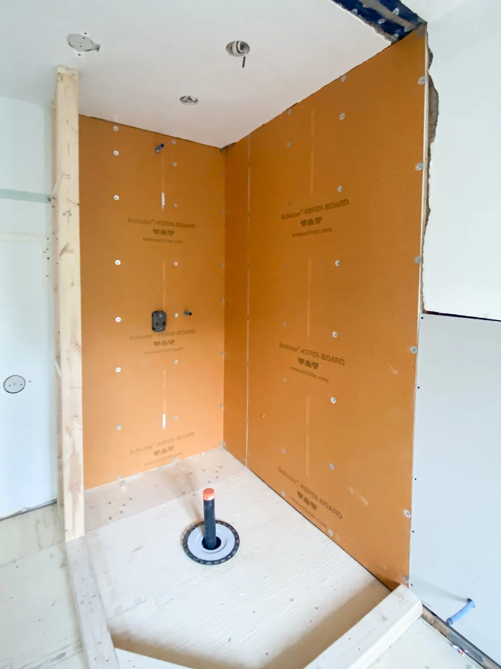 Shower area with KERDI-BOARD panels and adjoining bathroom drywall