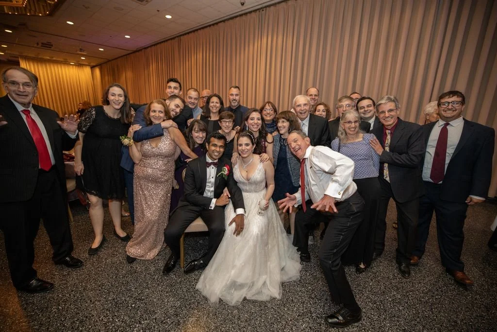 A wedding couple surrounded by their guests at the end of the night