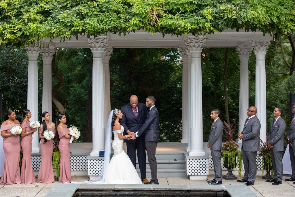 A wedding ceremony framed by classical white columns