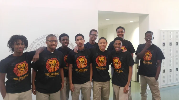 Students in matching Broadway show t-shirts smiling together