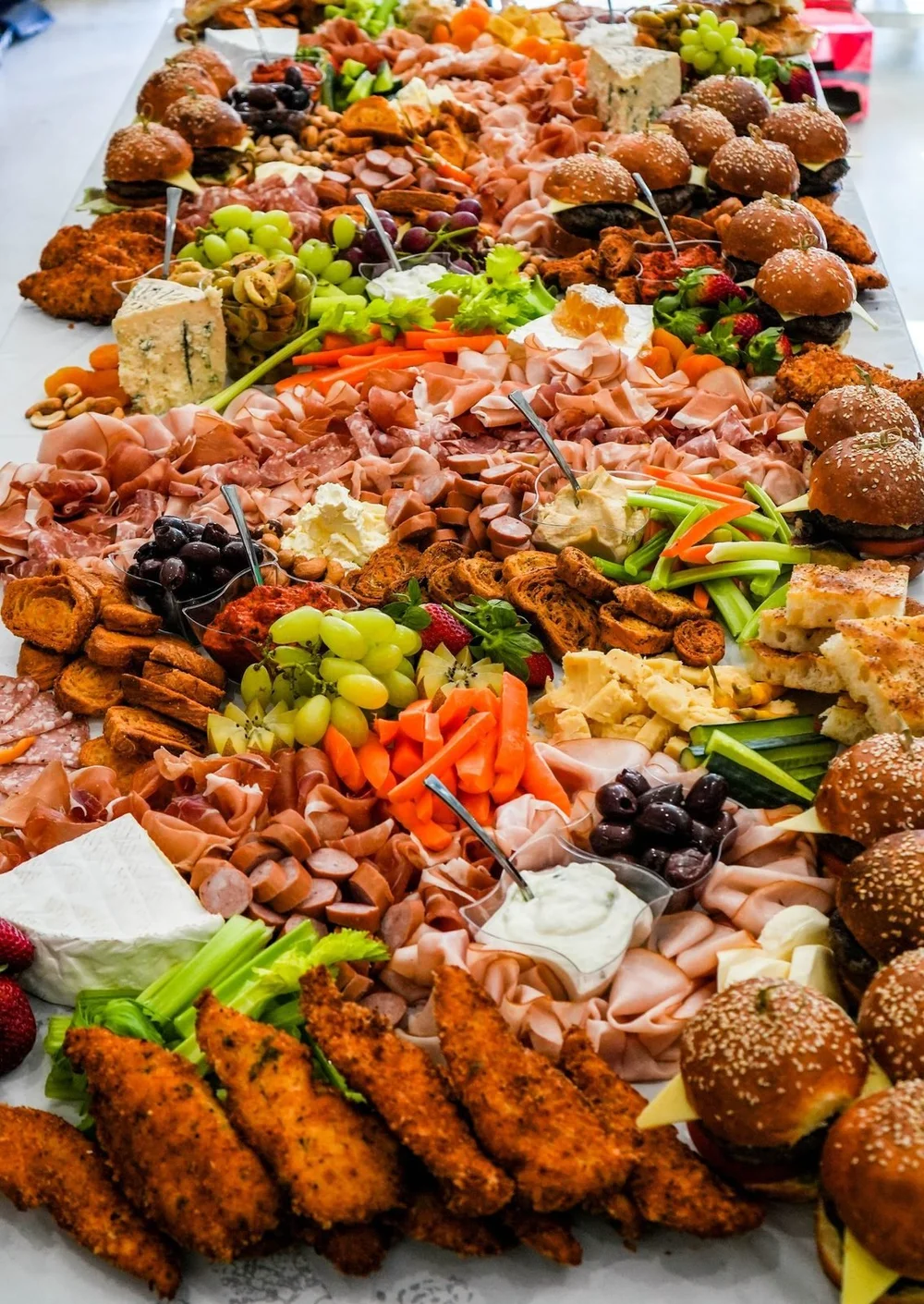 Long grazing table with sliders, cured meats and cheeses