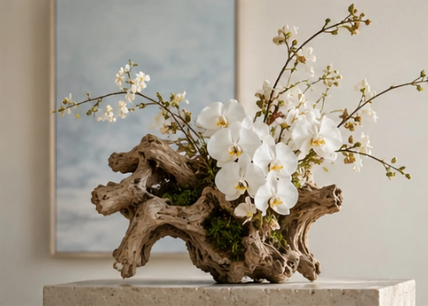White orchids and flowering branches in a sculptural driftwood vessel