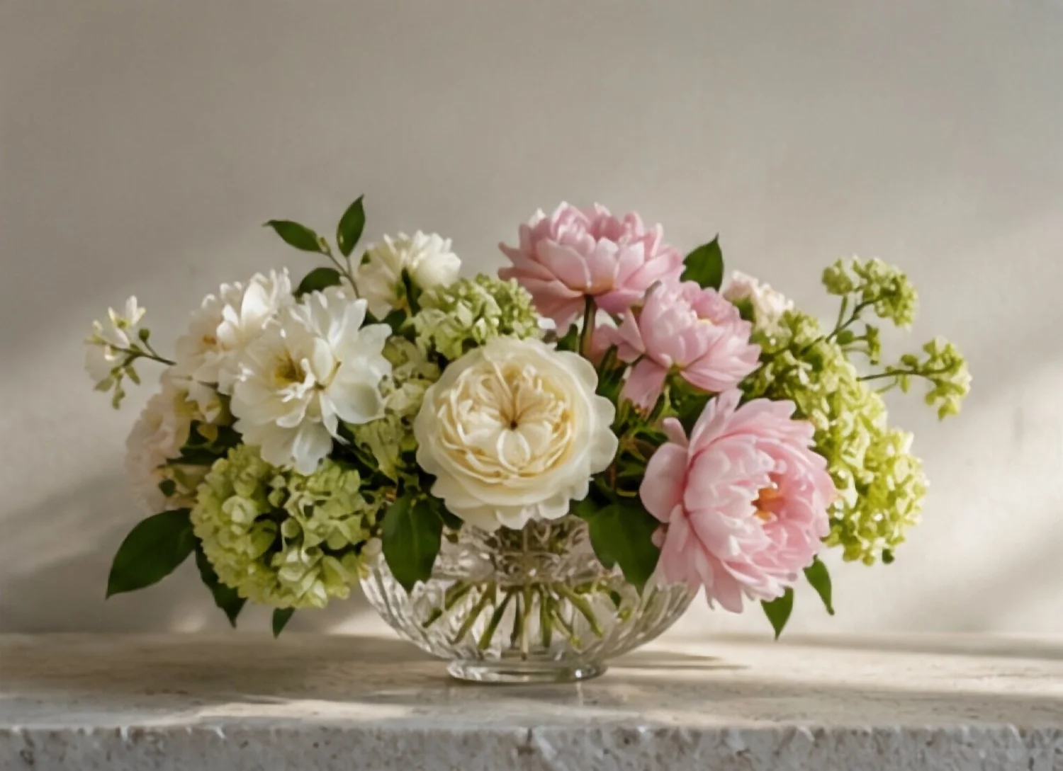 Blush peonies, garden roses and hydrangea in a crystal bowl