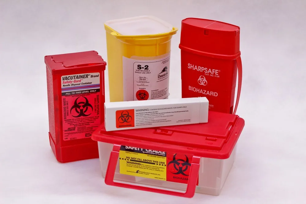 Red and yellow sharps disposal containers for used needles