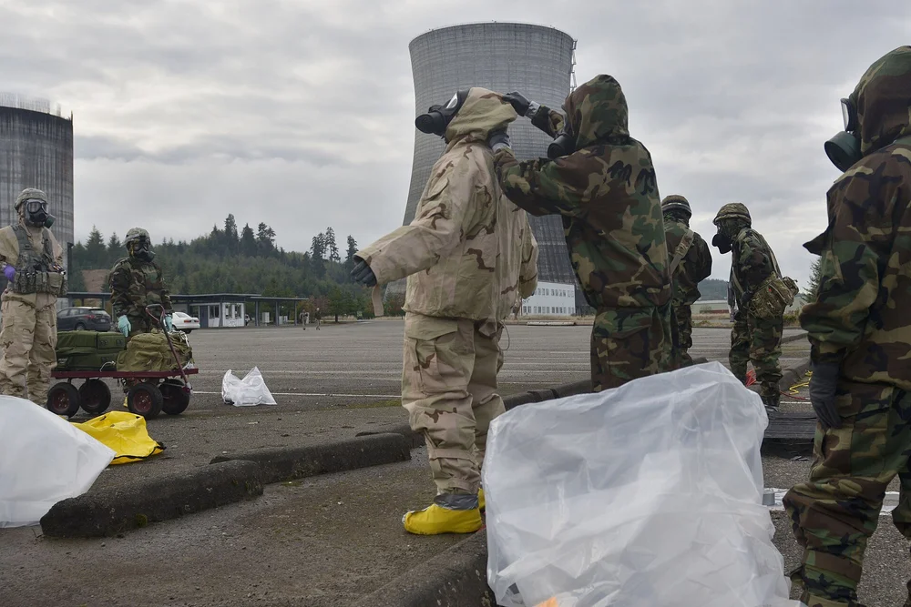 Responders in protective suits working through a decontamination line during a training exercise