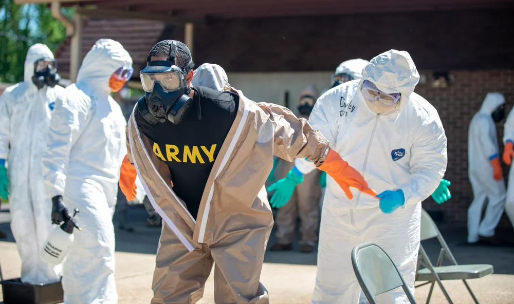 Team putting on white protective suits, gloves and masks before entering a work area