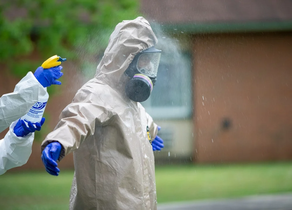 Worker in a full protective suit spraying disinfectant